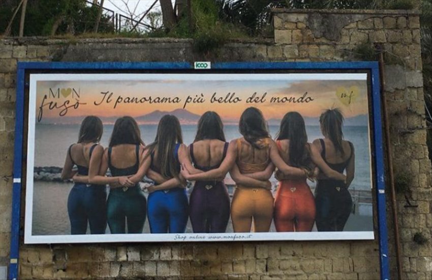 Lato B di 7 ragazze con il golfo di Napoli come sfondo: esplode la polemica per un cartellone pubblicitario a Posillipo