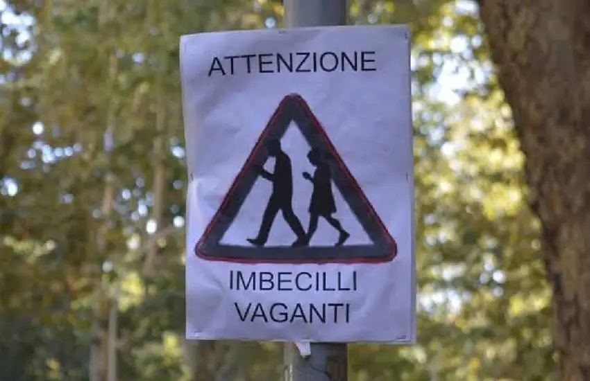 “Attenzione, imbecilli vaganti”; il curioso cartello che fa sorridere, ma fa anche riflettere, ideato dal titolare di un negozio di fotografia di Roma